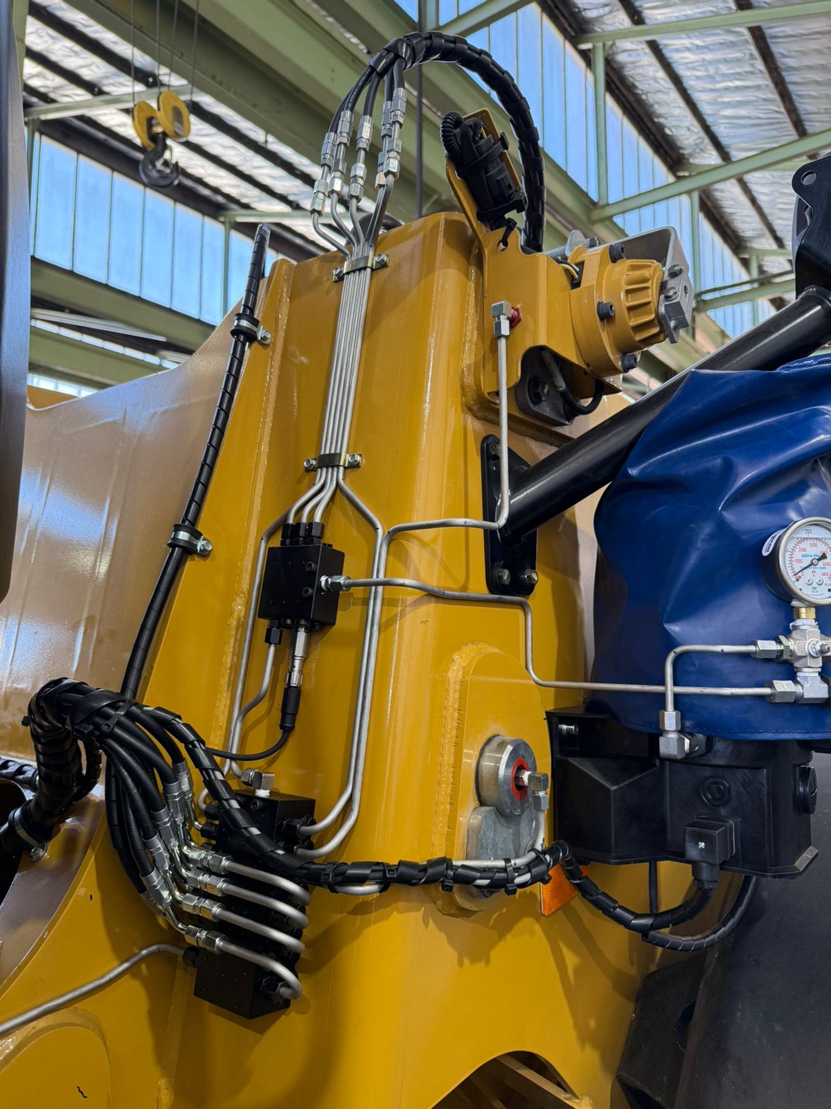 Lubrication lines routed between an excavator cab and boom