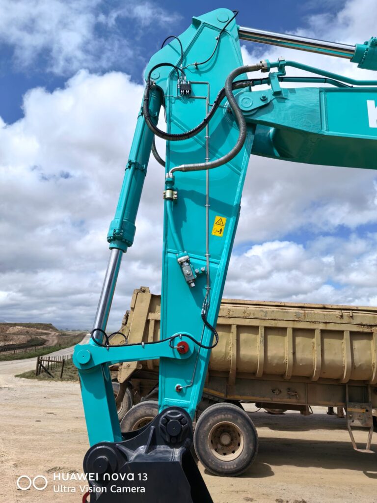 Lubrication lines routed along a Kobelco excavator boom