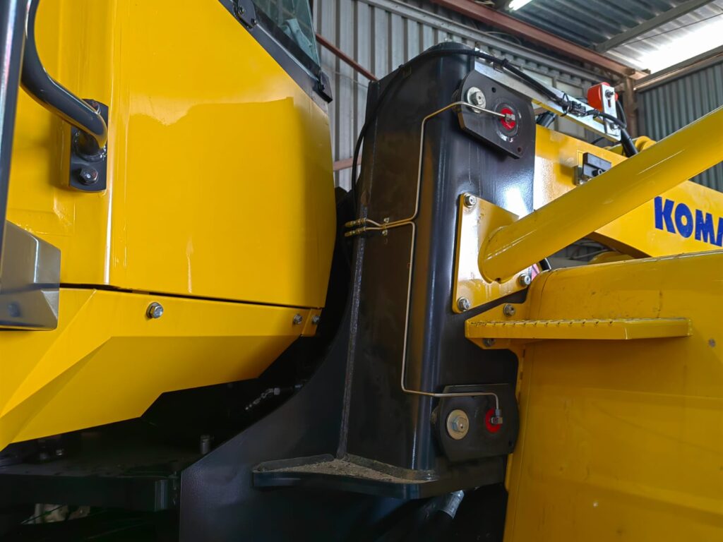 Lubrication lines fitted along a Komatsu loader arm
