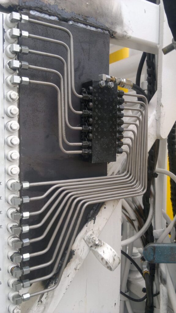 Progressive divider block with fanned stainless tubing