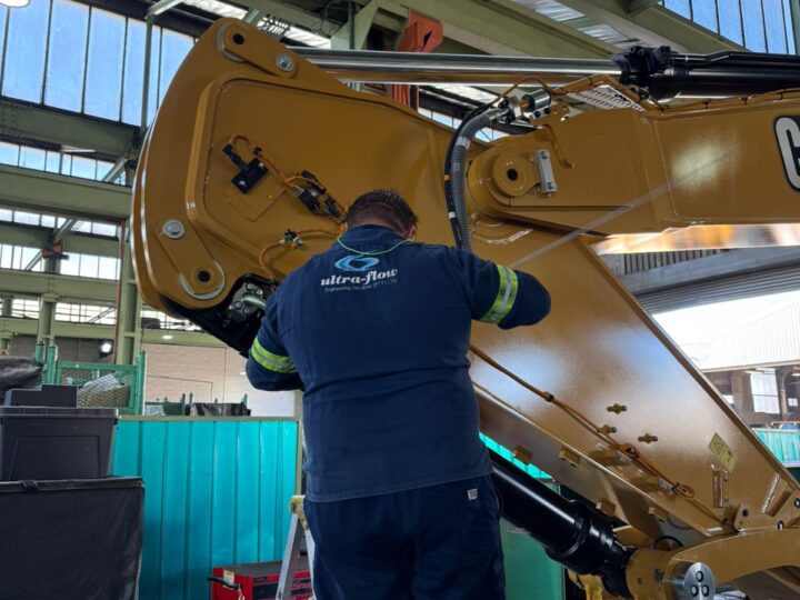 Ultra-Flow technician fitting a lubrication system to an excavator